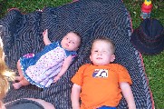 Amelia and Oliver lying on rug in garden